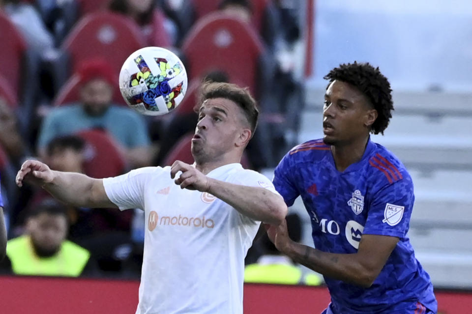 Chicago Fire's Xherdan Shaqiri, left, vies for possession of the ball with Toronto FC's Kosi Thompson during the first half of an MLS soccer match Saturday, May 28, 2022, in Toronto. (Jon Blacker/The Canadian Press via AP)