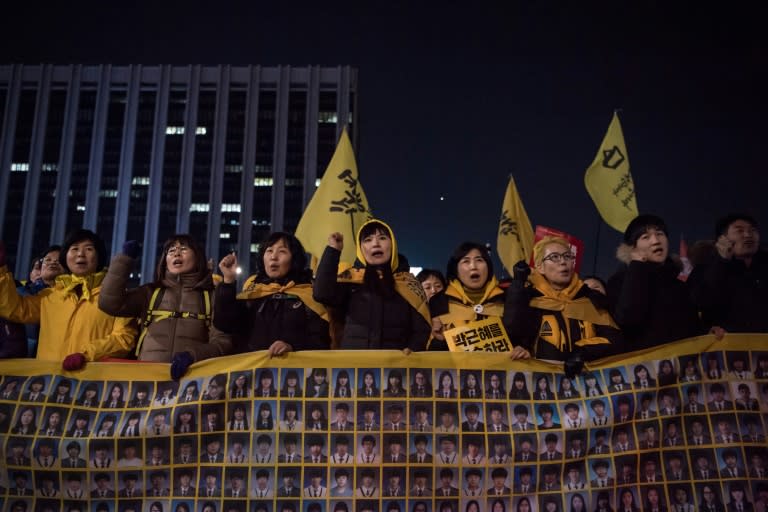 Relatives of victims of the 2014 Sewol ferry disaster join anti-government activists during a rally in Seoul on March 4, 2017