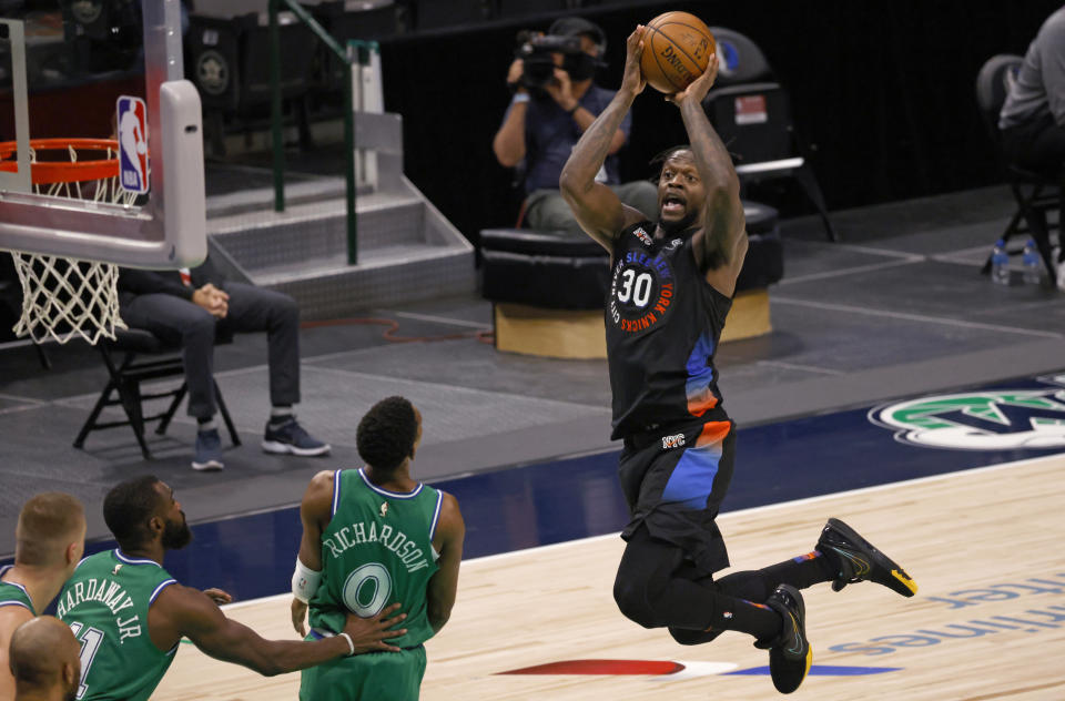 New York Knicks forward Julius Randle (30) drives inside to score as Dallas Mavericks guard Josh Richardson (0) and forward Tim Hardaway Jr. (11) watch during the second half of an NBA basketball game Friday, April 16, 2021, in Dallas. (AP Photo/Ron Jenkins)