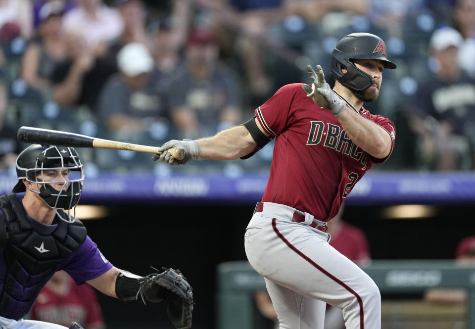 Arizona Diamondbacks' Cooper Hummel, right, follows the flight of his double that drove in two runs against Colorado Rockies starting pitcher Antonio Senzatela in the fourth inning of a baseball game Friday, Aug. 12, 2022, in Denver. (AP Photo/David Zalubowski)