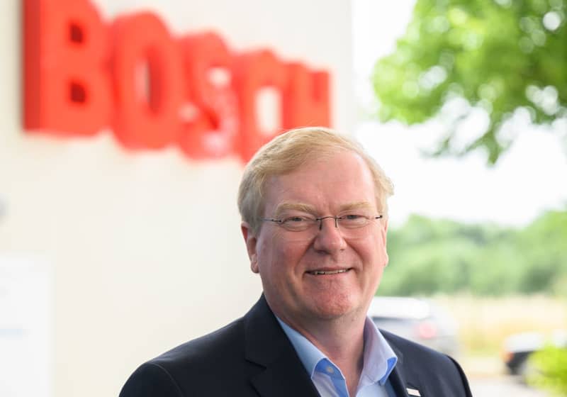 Stefan Hartung, Chairman of the Board of Management of Robert Bosch GmbH, stands in front of a semiconductor factory.  The chief executive of Germany's Bosch engineering group believes that vehicles running on internal combustion engines will be needed for at least 35 years before electrification of road transport can be complete. Robert Michael/dpa