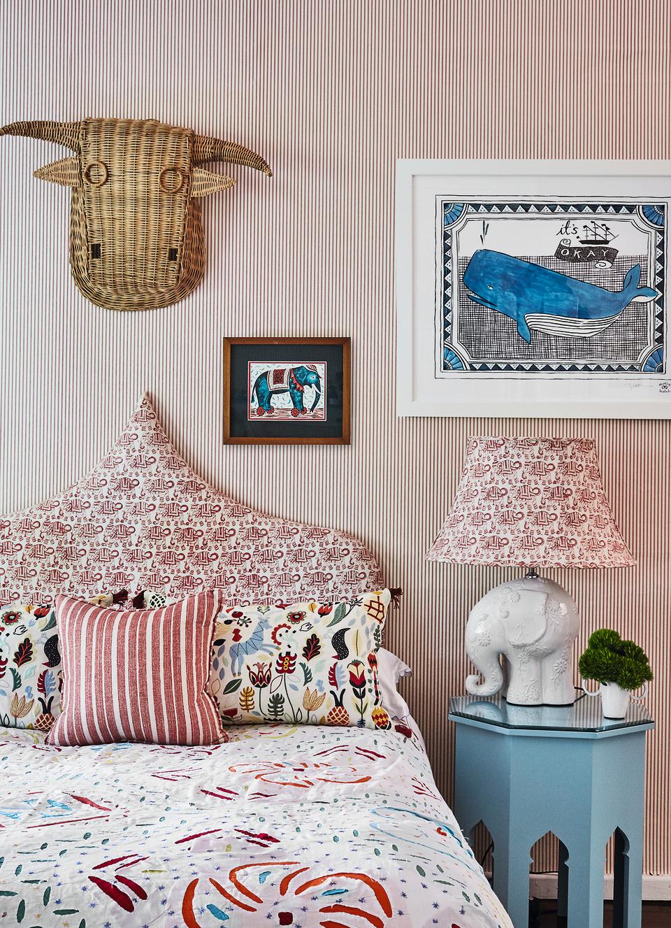 Children's wallpaper ideas featuring a red and white striped paper in a colorful patterned scheme, with contrasting prints on the headboard, bedlinen and accessories.