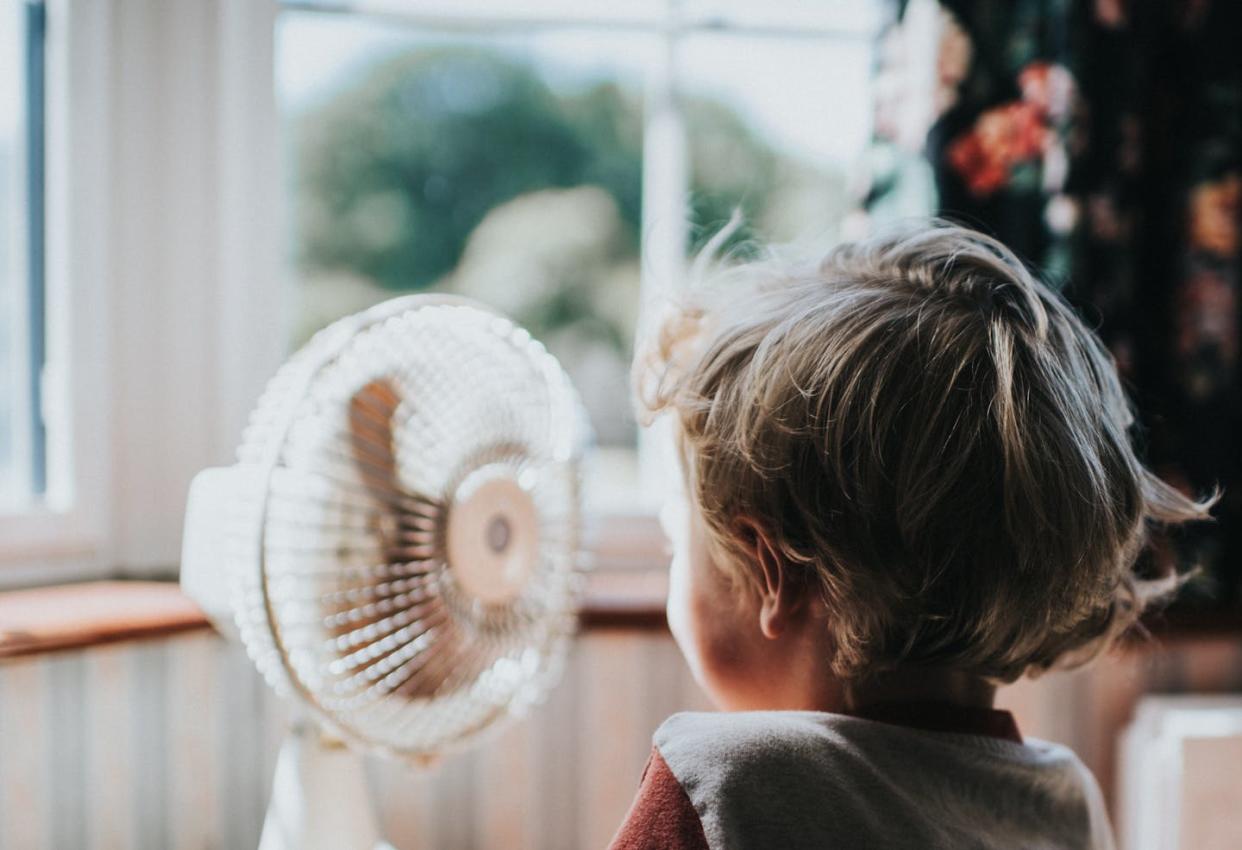 The temperature you feel on a hot, sunny day doesn't always match the thermostat. <a href="https://www.gettyimages.com/detail/photo/little-boy-looking-at-a-fan-royalty-free-image/1157634115" rel="nofollow noopener" target="_blank" data-ylk="slk:Catherine Falls Commercial/Moment via Getty Images;elm:context_link;itc:0;sec:content-canvas" class="link ">Catherine Falls Commercial/Moment via Getty Images</a>