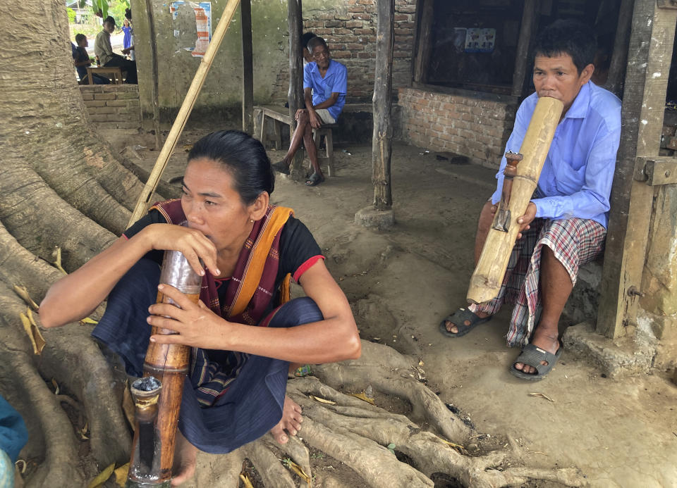 Chakma and other tribals sit and smoke from bamboos in Rangamati district of Bangladesh, Tuesday, Nov. 29, 2022. Bangladesh is marking 25 years since it signed a peace treaty to end an armed insurgency in southeastern Bangladesh. (AP Photo/Al-emrun Garjon)