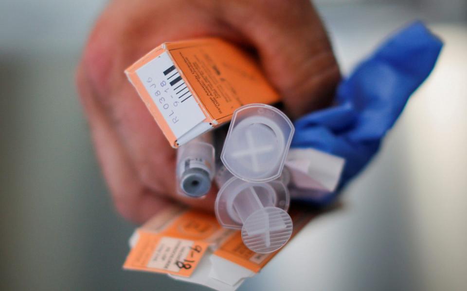 A medic holds used doses of naloxone - Reuters