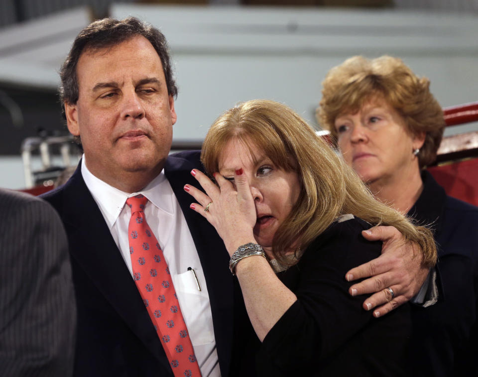 Amy Peters, of Manahawkin, N.J., wipes a tear as she is hugged by New Jersey Gov. Chris Christie Thursday, Jan. 16, 2014, in Manahawkin, N.J., as he meets with homeowners who lost their homes last year to Superstorm Sandy. Christie spoke to Superstorm Sandy victims one week after the meeting was hastily canceled because of a scandal over traffic jams that appear to have been manufactured by his aides. Christie and Community Affairs Commissioner Richard Constable III announced a Sandy housing recovery milestone Thursday as the governor seeks to put the traffic scandal behind him. (AP Photo/Mel Evans)