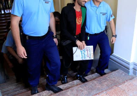 A defendant arrives in the courtroom after a break in a trial of men charged with causing the death of 71 migrants who suffocated in a lorry found beside an Austrian motorway in 2015, in Kecskemet, Hungary June 21, 2017. REUTERS/Bernadett Szabo