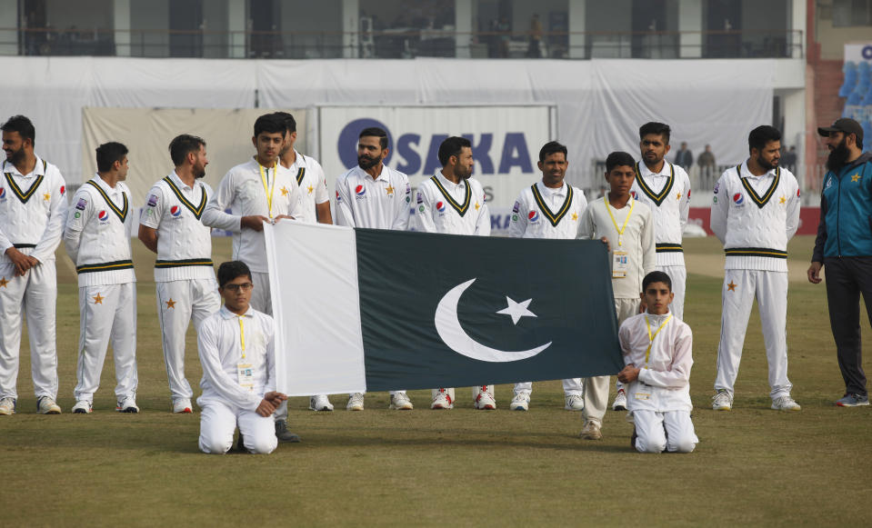 Pakistani players stand for national anthem before start the game of first day of 1st cricket test match between Pakistan and Sri Lanka, in Rawalpindi, Pakistan, Wednesday, Dec. 11, 2019. (AP Photo/Anjum Naveed)