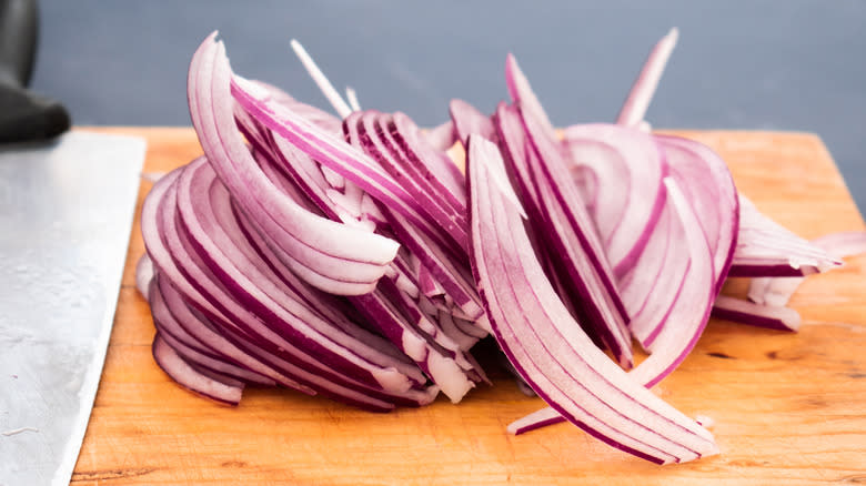 Emincer cut onions on board