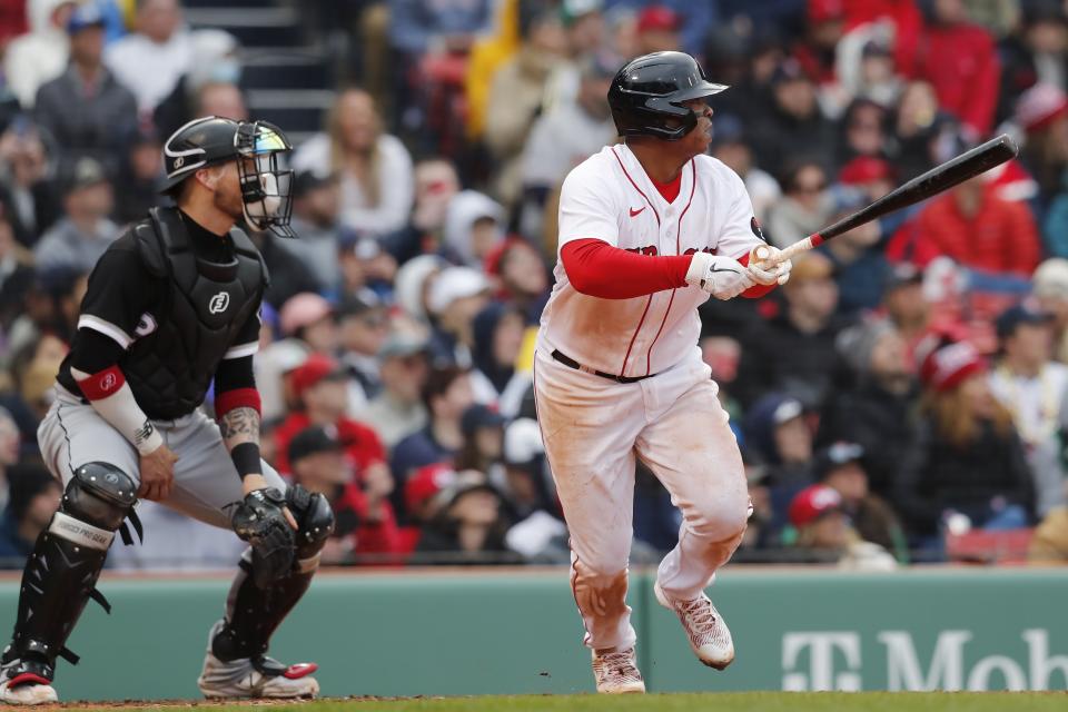 Boston Red Sox's Rafael Devers, right, watches his RBI-double in front of Chicago White Sox's Yasmani Grandal during the fifth inning of a baseball game, Saturday, May 7, 2022, in Boston. (AP Photo/Michael Dwyer)