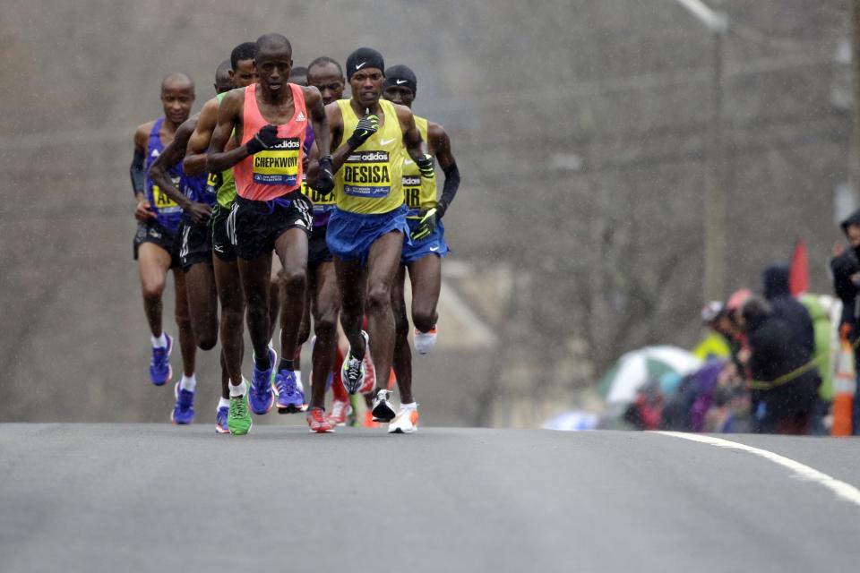 FILE - In this April 20, 2015, file photo, Frankline Chepkwony, front left, of Kenya, and Lelisa Desisa, right, of Ethiopia, lead the pack up Heartbreak Hill during the Boston Marathon in Newton, Mass. Due to the COVID-19 virus pandemic, the 124th running of the Boston Marathon was postponed from its traditional third Monday in April to Monday, Sept. 14, 2020. (AP Photo/Steven Senne, File)