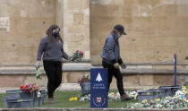 Collected flowers are placed on the lawn inside Windsor Castle after the death of Britain's Prince Philip in Windsor, Sunday, April 11, 2021. Britain's Prince Philip, the irascible and tough-minded husband of Queen Elizabeth II who spent more than seven decades supporting his wife in a role that mostly defined his life, died on Friday. (AP Photo/Frank Augstein)