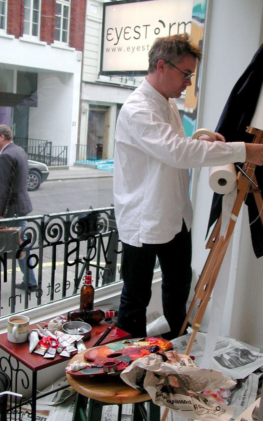 Damien Hirst in the window of the art gallery Eyestorm in central London in 2001, working on his work of art, which was later thrown away by a cleaner, who thought it was a pile of old rubbish