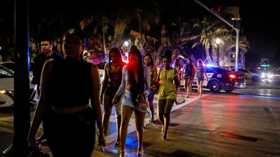 PHOTO: People walk on Ocean Drive with Police in the back during Spring Break in Miami Beach, Florida, on March 24, 2022. (Eva Marie Uzcategui/AFP via Getty Images, FILE)