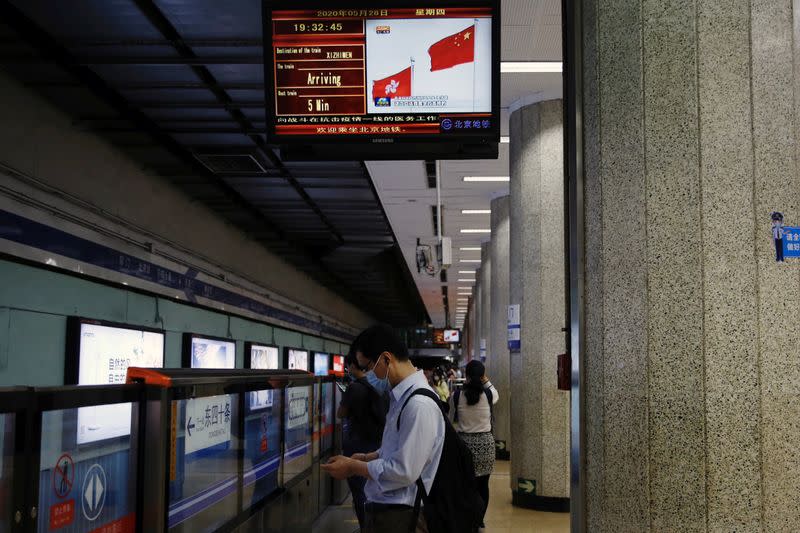 Screen showing news footage of Chinese and Hong Kong flags in Beijing