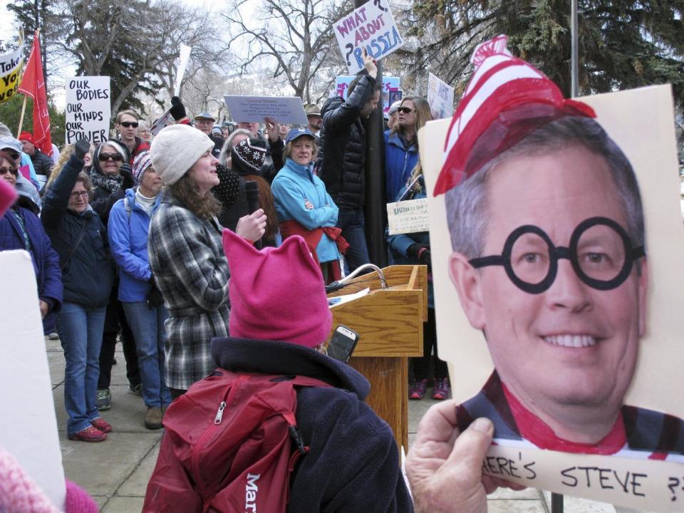 Katherine Haque-Hausrath, with a microphone, , one of the organizers for a rally, addresses a crowd outside the Montana Capitol in Helena on Tuesday, Feb. 21, 2017. Hundreds of protesters who were upset that U.S. Sen. Steve Daines wasn't planning a town hall this week decided to bring one to him instead outside of the Montana Capitol, where Daines was scheduled to address the state Legislature on Tuesday. (AP Photo/Matt Volz)