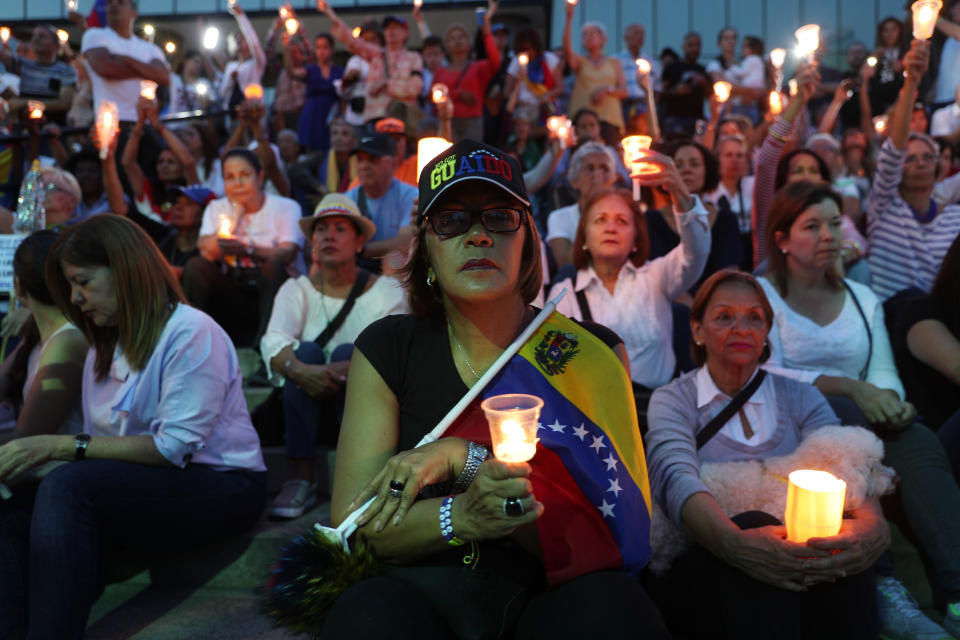 Opponents to Venezuela's President Nicolas Maduro hold a vigil for those killed in street fighting over the past week in Caracas, Venezuela, Sunday, May 5, 2019. Opposition leader Juan Guaidó called in vain for a military uprising to overthrow President Nicolas Maduro, and five people were killed in clashes between protesters and police. (AP Photo/Martin Mejia)
