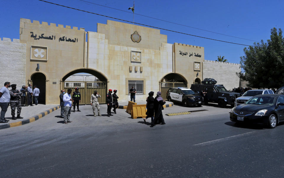 Security forces stand outside the state security court where the trial of Bassem Awadallah, a former royal adviser, and Sharif Hassan bin Zaid, a distant cousin of the king, is taking place, in Amman, Jordan, Monday, June. 21, 2021. Awadallah, who has Jordanian, U.S. and Saudi citizenship, and bin Zaid, pleaded not guilty Monday to sedition and incitement charges, a defense lawyer said. The defendants are accused of conspiring with a senior royal — Prince Hamzah, a half-brother of the king — to foment unrest against the monarch while soliciting foreign help. (AP Photo/Raad Adayleh)