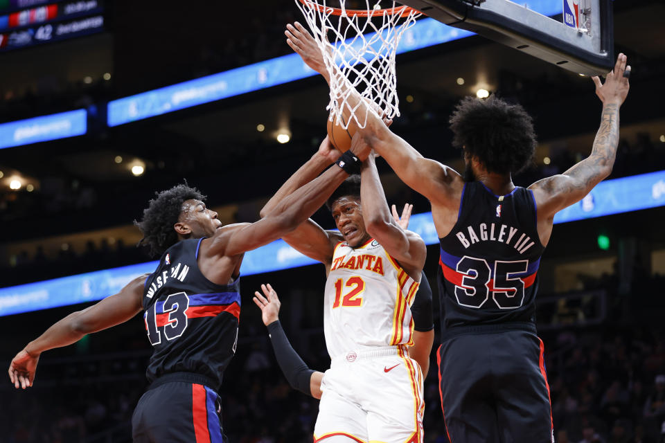 Detroit Pistons center James Wiseman, left, and forward Marvin Bagley III, right, guard Atlanta Hawks forward De'Andre Hunter during the first half of an NBA basketball game Tuesday, March 21, 2023, in Atlanta. (AP Photo/Alex Slitz)