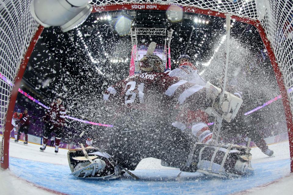 Latvia's goalkeeper Edgars Masalskis (C) makes a save during the Men's Ice Hockey Group C match Czech Republic vs Latvia at the Bolshoy Arena during the Sochi Winter Olympics on February 14, 2014.  