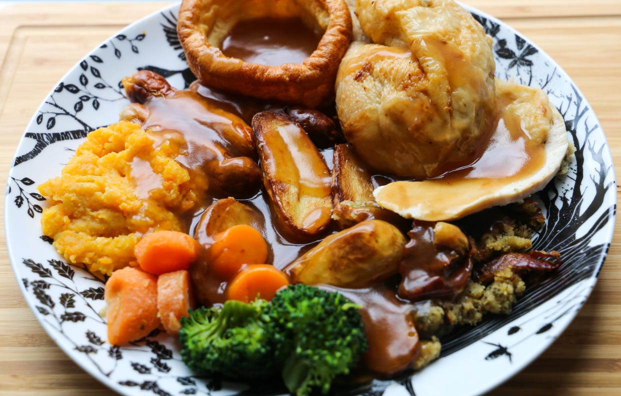 Traditional British Sunday roast dinner with chicken, vegetables, gravy and a Yorkshire pudding.