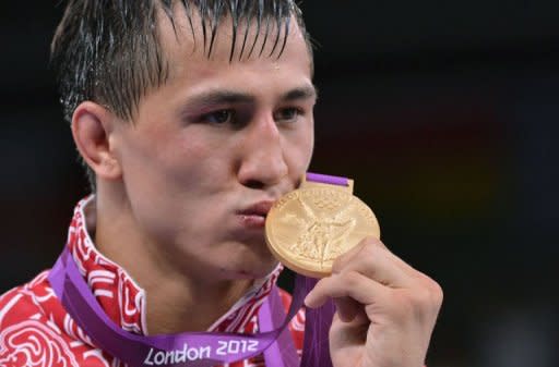 Russian gold medalist Roman Vlasov kisses his medal as he poses on the podium of the 74kg Greco Roman Wrestling Final match of the London 2012 Olympic Games at the Excel Centre in London