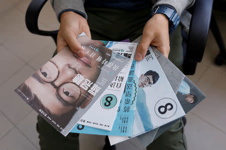 Student activist Isaac Cheng shows campaign leaflets of party member Nathan Law who win a seat for Legislative Council election in 2016, than disqualified in July for embellishing his oath during interview at Demosisto party's office in Hong Kong, China December 8, 2017. REUTERS/Tyrone Siu