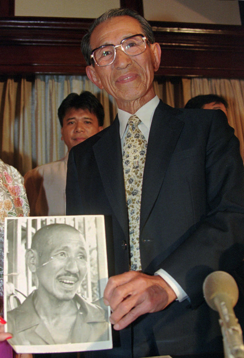 FILE - In this May 20, 1996 file photo, former Japanese straggler Hiroo Onoda holds a picture of himself, taken for the first time when he came out of hiding from the jungle, during a news conference upon arrival in Manila, Philippines, for a sentimental journey. Onoda, the last Japanese imperial soldier to emerge from hiding on Lubang Island and surrender after World War II, has died. He was 91. Onoda died Thursday, Jan. 16, 2014 at a Tokyo hospital. (AP Photo/Bullit Marquez, File)