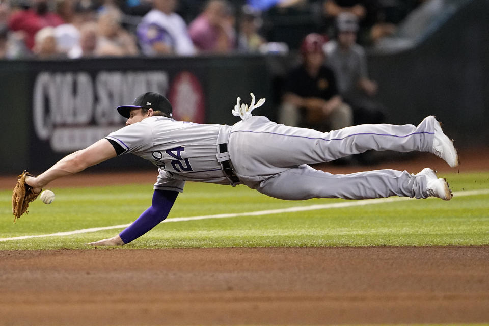 Colorado Rockies' Ryan McMahon can't stop a double hit by Arizona Diamondbacks' Lourdes Gurriel Jr. during the fourth inning of a baseball game, Tuesday, Sept. 5, 2023, in Phoenix. (AP Photo/Matt York)