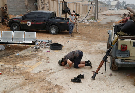 A fighter loyal to Libya's U.N.-backed government (GNA) prays during clashes with forces loyal to Khalifa Haftar on the outskirts of Tripoli, Libya May 25, 2019. REUTERS/Goran Tomasevic