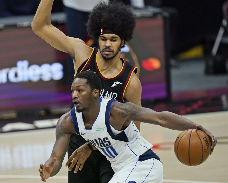 Dallas Mavericks' Dorian Finney-Smith, front, drives against Cleveland Cavaliers' Jarrett Allen during the second half of an NBA basketball game Sunday, May 9, 2021, in Cleveland. Dallas won 124-97. (AP Photo/Tony Dejak)