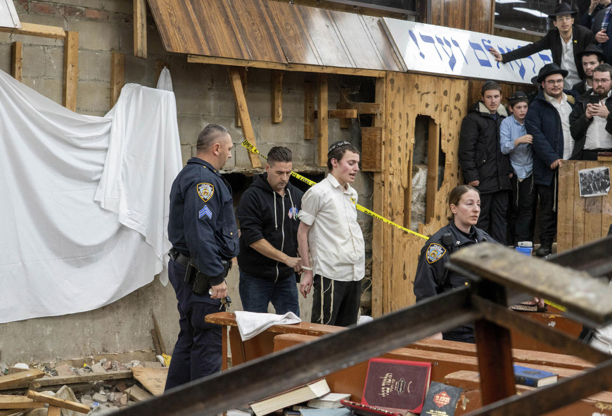 New York Police officers arrest a Hasidic Jewish student on Monday after he was removed from a breach in the wall of the synagogue.  (Bruce Schaff / AP)