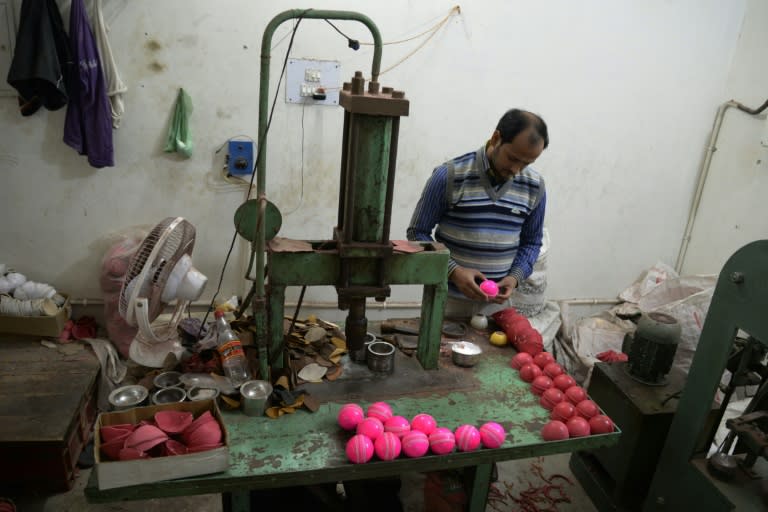 An Indian cricket ball maker examines pink balls at the Chhaju Ram workshop in Jalandhar on November 28, 2015