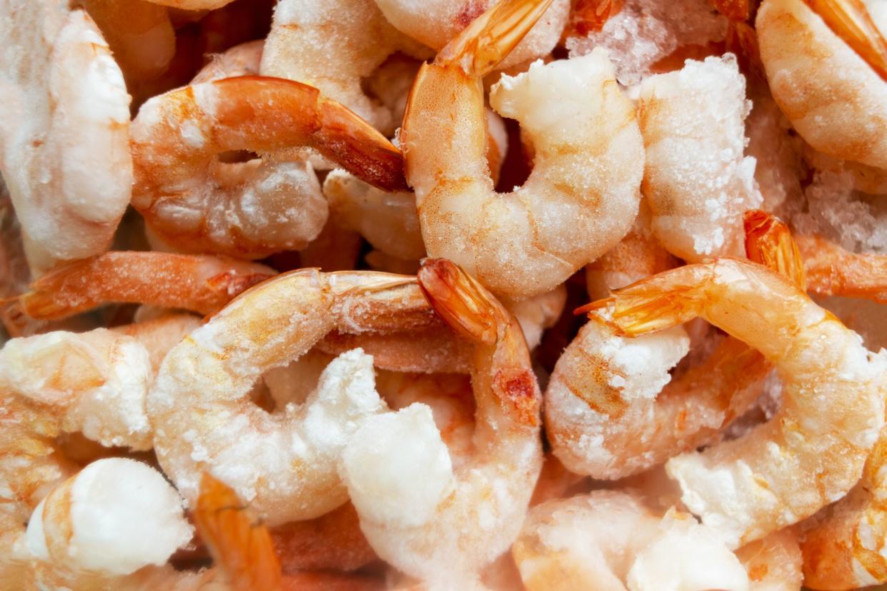 Raw frozen and peeled shrimp background. Pile of frozen shrimps  .Close-up of frozen shrimps. A lot of royal shrimp macro shot