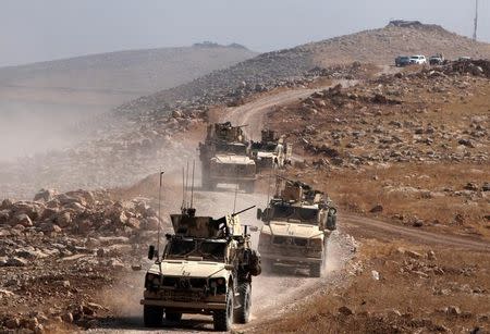 A convoy of armoured vehicles belonging to international coalition troops drive during the operation against Islamic State militants outside the town of Naweran near Mosul, Iraq October 23, 2016. REUTERS/Azad Lashkari