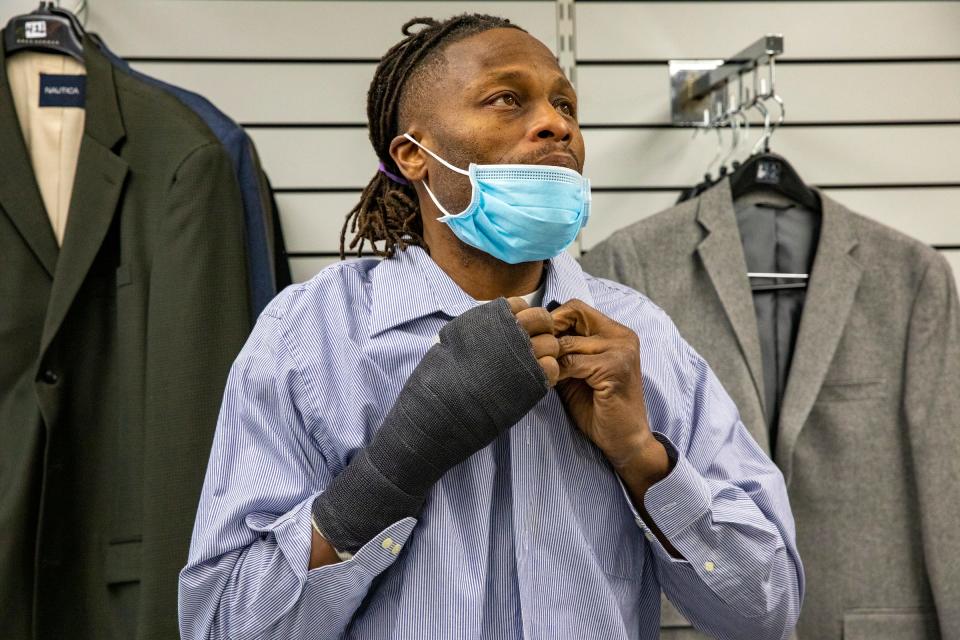 Archie King, 42, of Detroit looks for nice business clothes to wear to jobs and job interviews at Jackets for Jobs boutique in Detroit on Wednesday, Dec. 8, 2021.  Jackets for Jobs also provides guidance that helps people obtain sustained employment and rebuild their lives for the long term.