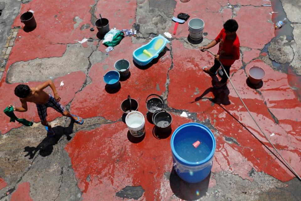 Youth migrants from Central America play with water inside a migrant shelter in Nuevo Laredo, Mexico in June 2019.