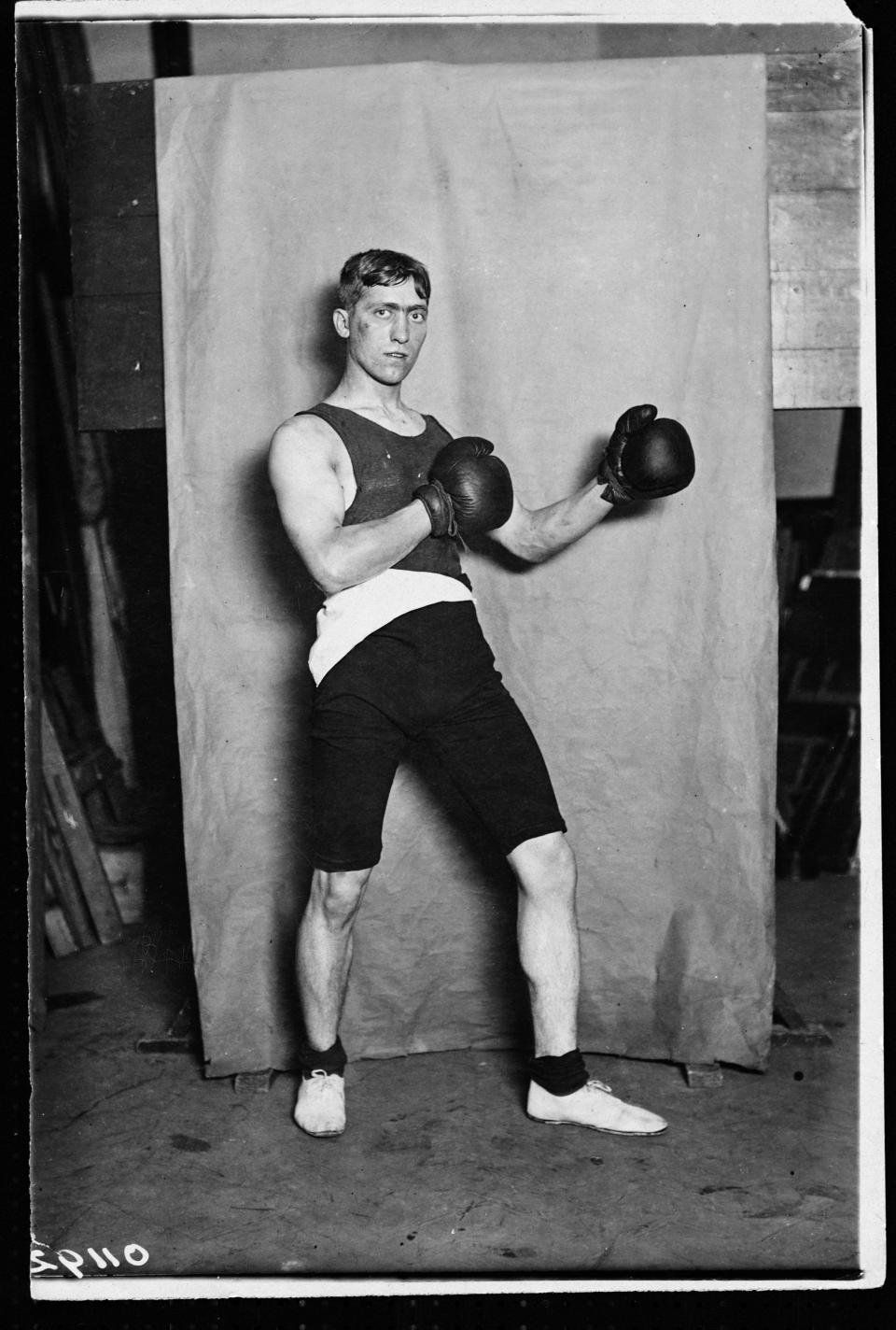 Frederick Grace poses for a black and white photo with boxing gloves on in 1908.