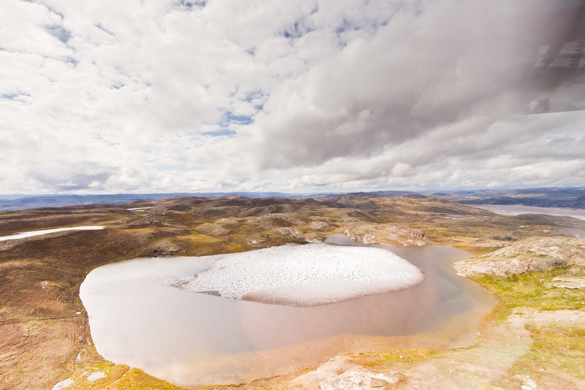 Melting ice on a small Greenland tundra pond.