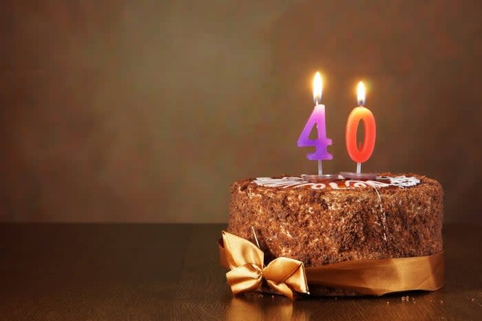 A chocolate birthday cake with candles that say 40.