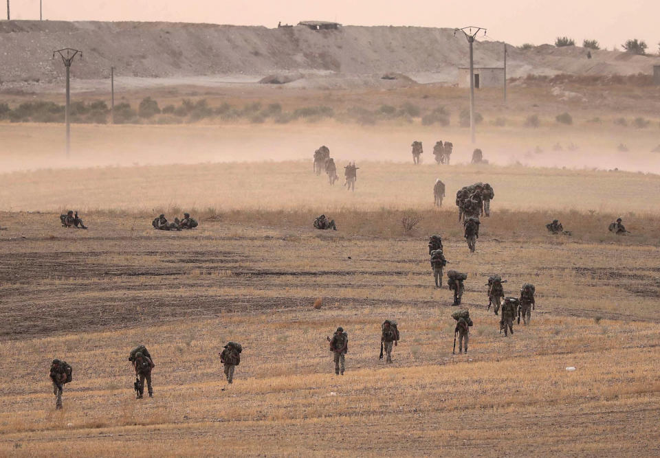 In this Monday, Oct.14, 2019 photo made available Tuesday, Oct. 15, 2019, Turkey's forces advance towards Manbij, Syria. U.S. military spokesman says U.S. forces have left Kurdish-held town of Manbij, part of withdrawal from northeast Syria. (Ugur Can/DHA via AP)