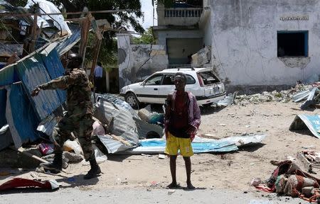 A civilian who was wounded following a car bomb claimed by al Shabaab Islamist militants outside the president's palace stands near the scene of the explosion in the Somali capital of Mogadishu, August 30, 2016. REUTERS/Feisal Omar