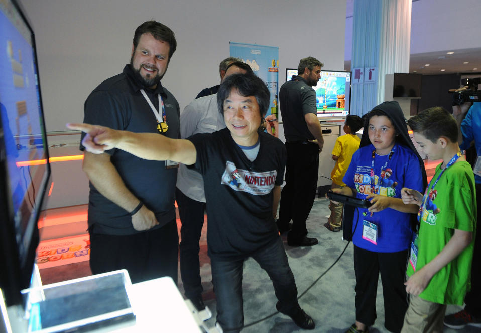 LOS ANGELES, CA - JUNE 11: In this photo provided by Nintendo of America, Oscar, age 11, and Noah, age 13, join Shigeru Miyamoto, the creator of Super Mario Bros. and The Legend of Zelda, for a collaborative game play session with Mario Maker (working title), an upcoming game for the Wii U console unveiled at the E3 trade show on June 11, 2014 in Los Angeles, California. For the first time ever, Nintendo is giving the world a glimpse of the thrill of E3 through the eyes of a child by welcoming a select group of kids to the Nintendo Kids Corner event at the Nintendo booth at E3. They enjoyed an exclusive, insider's look at the latest games announced for the Wii U console and the Nintendo 3DS system. (Photo by Bob Riha, Jr./Nintendo via Getty Images)