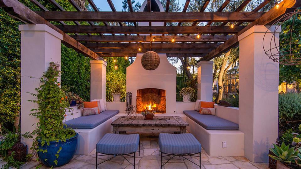 A cozy outdoor seating area equipped with a fireplace. - Credit: Redfin