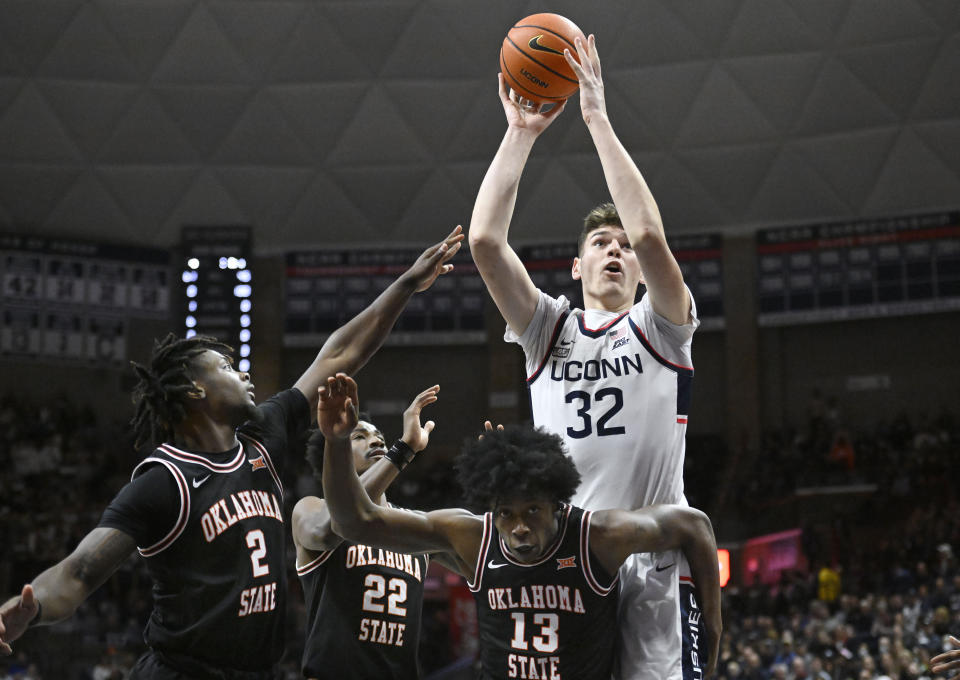 Connecticut's Donovan Clingan (32) shoots over Oklahoma State's Chris Harris Jr. (2), Kalib Boone (22) and Quion Williams (13) in the first half of an NCAA college basketball game, Thursday, Dec. 1, 2022, in Storrs, Conn. (AP Photo/Jessica Hill)