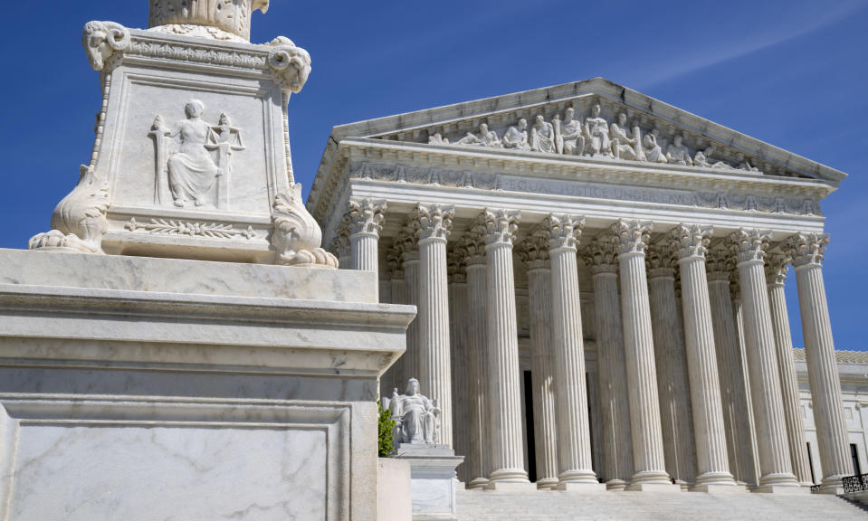 FILE - The U.S. Supreme Court is seen, with a carving of Justice in the foreground, April 19, 2023, in Washington. A Black Ohio woman who miscarried in her bathroom has been charged with abuse of a corpse and awaits grand jury action. Her case has sparked a national firestorm over the plight of pregnant women, especially women of color, following the U.S. Supreme Court’s decision to overturn Roe v. Wade. (AP Photo/Jacquelyn Martin, File)