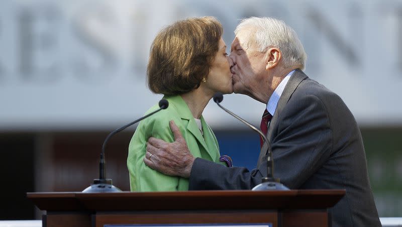 This Oct. 1, 2009, file photo shows former President Jimmy Carter getting a kiss from his wife Rosalynn as she introduces him during a reopening ceremony for the newly redesigned Carter Presidential Library in Atlanta.
