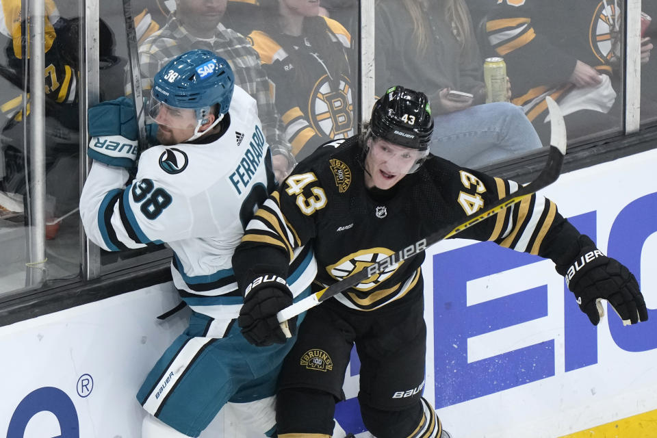 San Jose Sharks defenseman Mario Ferraro (38) and Boston Bruins left wing Danton Heinen (43) crash into the boards in the second period of an NHL hockey game, Thursday, Nov. 30, 2023, in Boston. (AP Photo/Steven Senne)