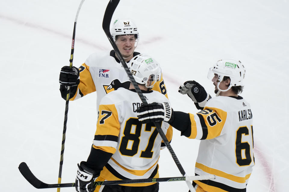 Pittsburgh Penguins center Sidney Crosby (87) celebrates with right wing Rickard Rakell (67) and defenseman Erik Karlsson (65) after scoring in the third period of an NHL hockey game against the Boston Bruins, Thursday, Jan. 4, 2024, in Boston. (AP Photo/Steven Senne)