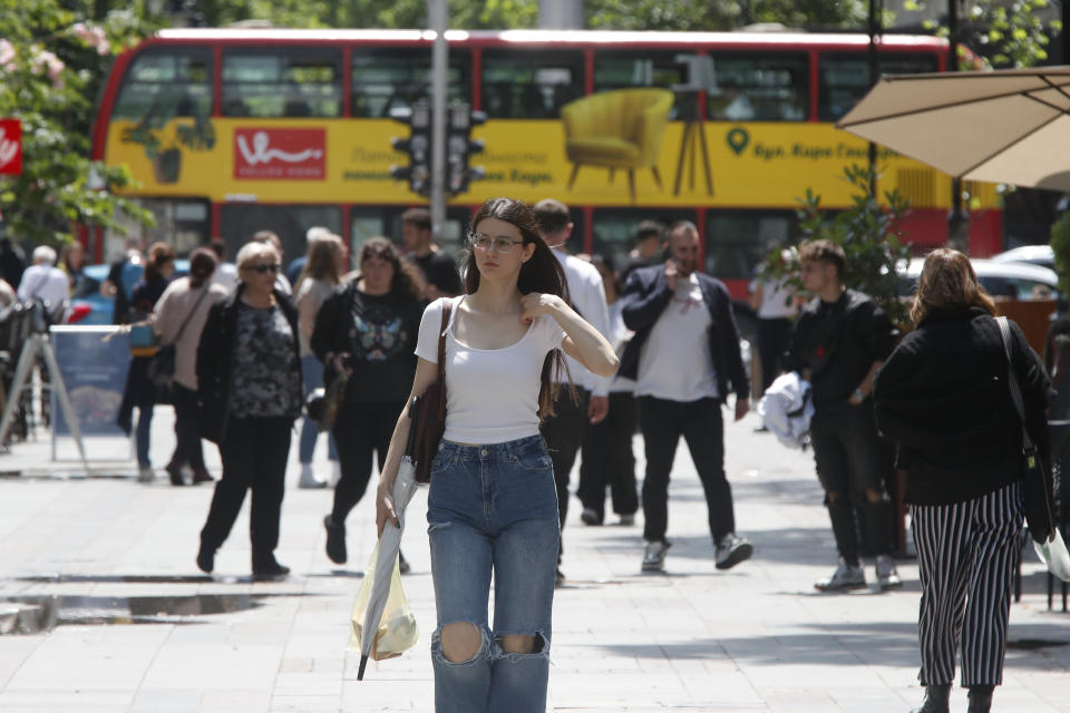 People walk through a street in downtown Skopje, North Macedonia, a day after the presidential and parliamentary elections, on Thursday, May 9, 2024. North Macedonia elected its first woman president Wednesday as the governing Social Democrats suffered historic losses in twin presidential and parliamentary elections. (AP Photo/Boris Grdanoski)